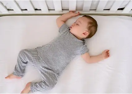 Baby sleeping on his back in a crib