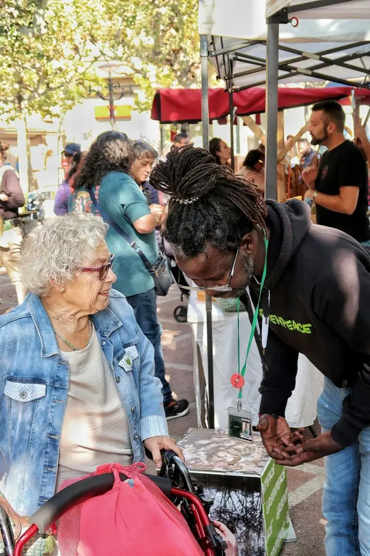 A man talking to an elderly lady at a festival